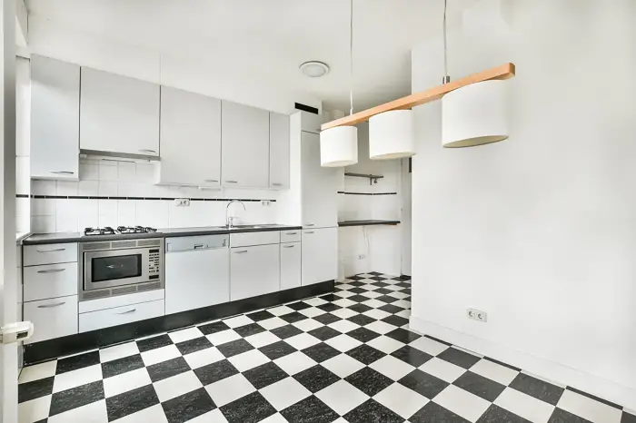 Cuisine moderne avec carrelage noir et blanc posé sur un sol parfaitement ragréé