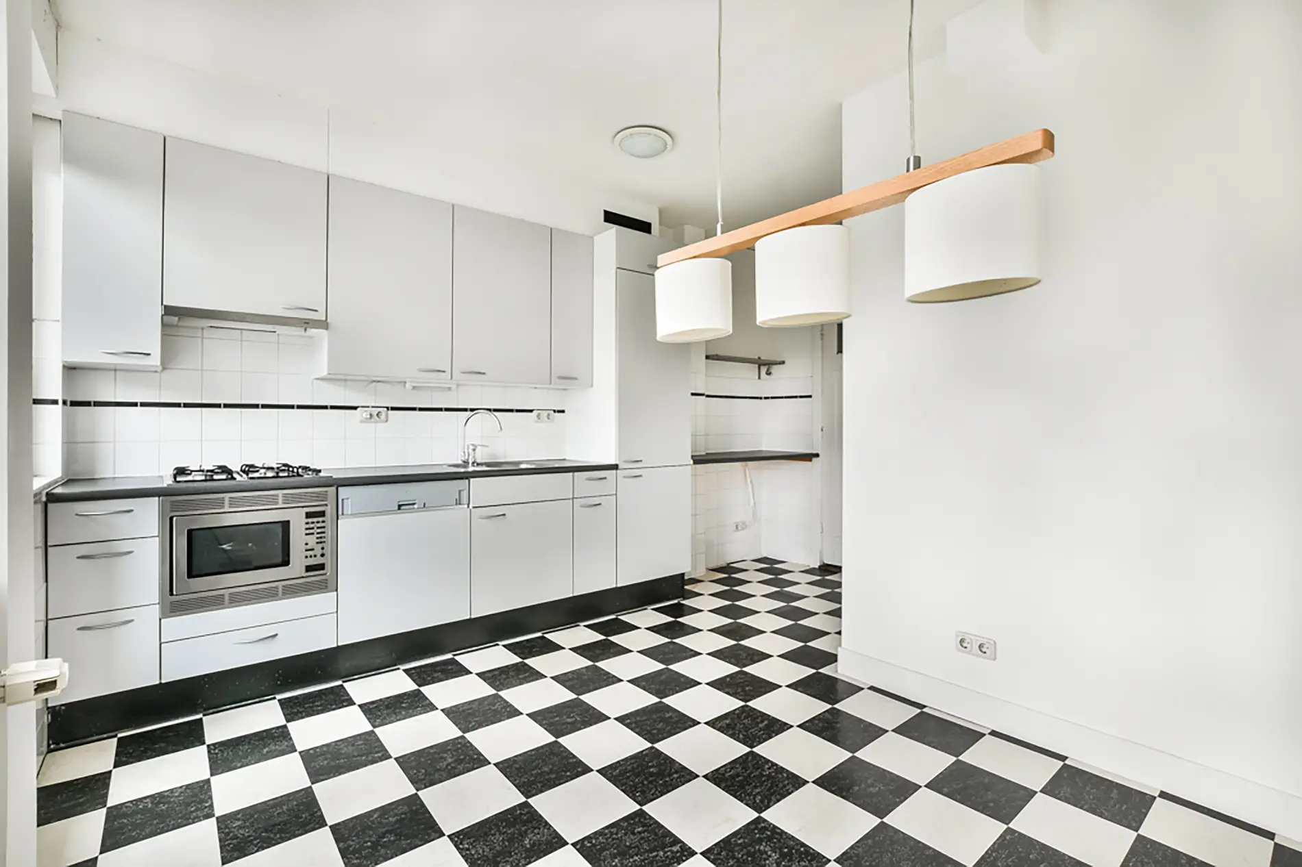 Pose de carrelage intérieur au Haillan dans une cuisine moderne avec motifs noir et blanc.