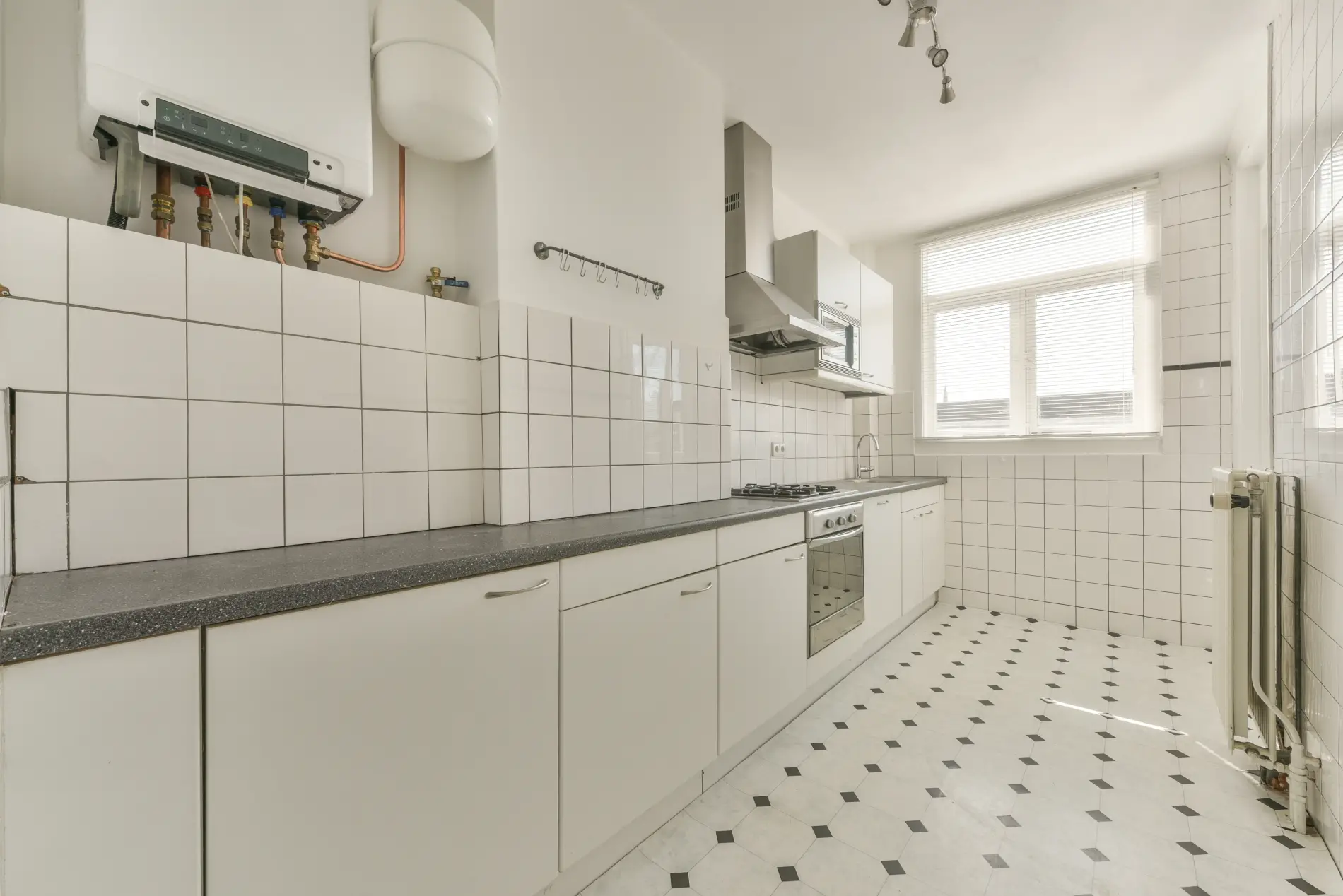 Cuisine avec carrelage blanc impeccable après nettoyage post-chantier par nos artisans à Bruges