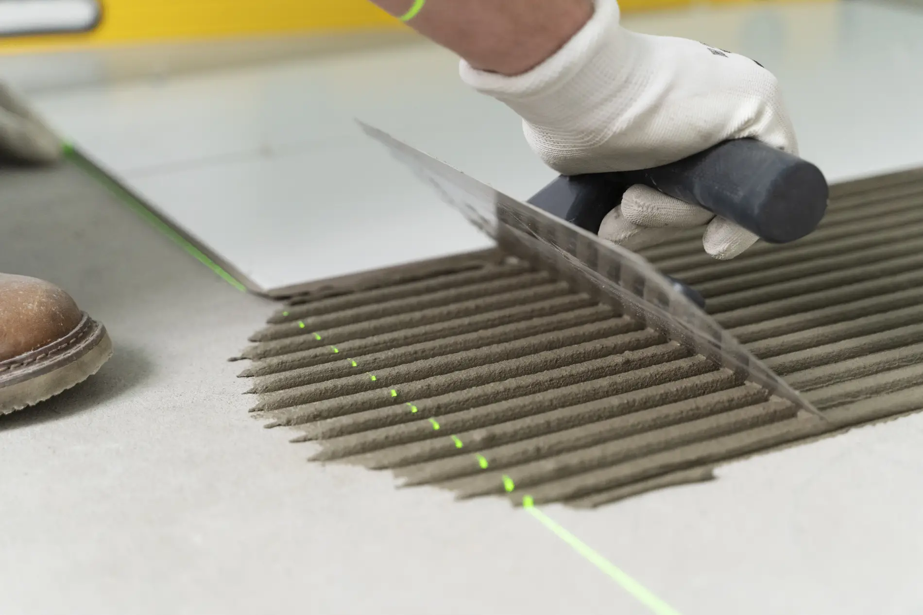 Carreleur professionnel en pleine pose d'un carrelage grand format à Mérignac